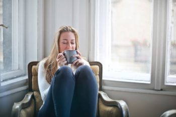 Woman holding coffee mug next to window in Smyrna