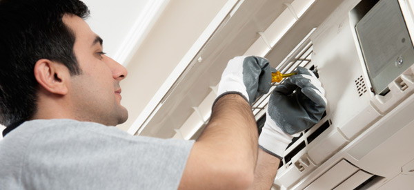 HVAC technician repairing an AC unit 