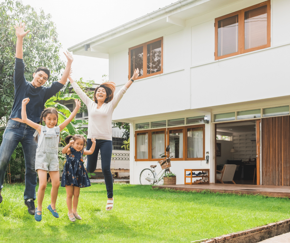 A happy family jumping together in their yard