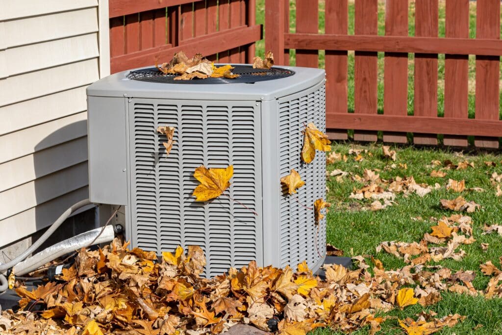 Condenser unit covered in fall leaves