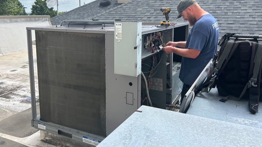 HVAC tech repairing commercial air conditioning.