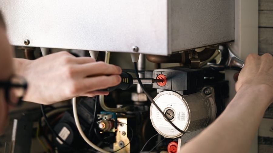 HVAC tech maintaining heating unit.
