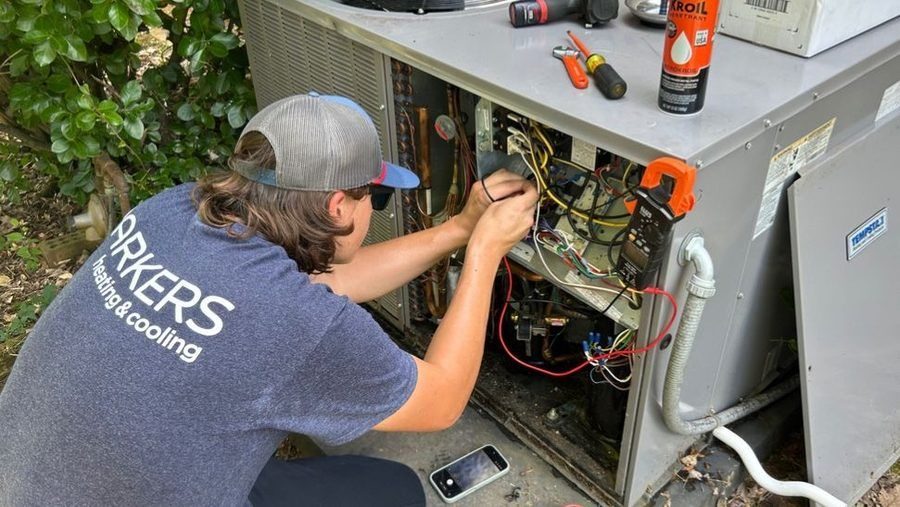Technician repairing AC unit.