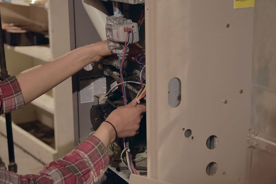 HVAC technician performing maintenance and repairs on a furnace