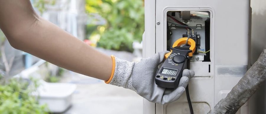 HVAC technician performing maintenance on an outdoor HVAC unit